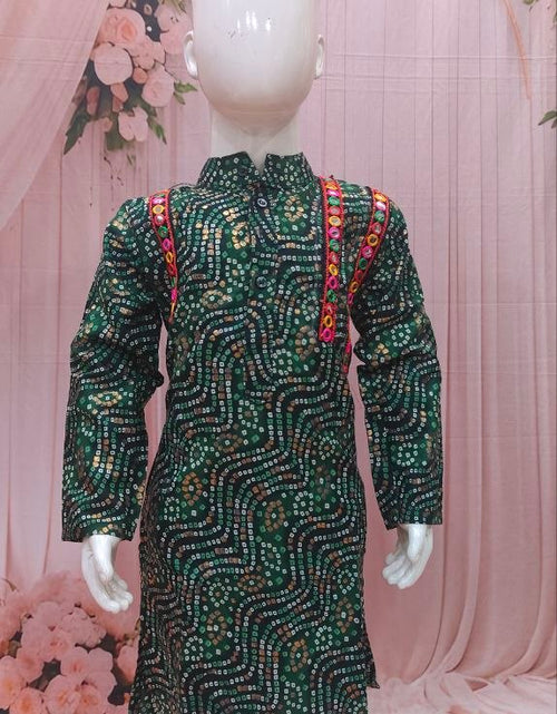 Load image into Gallery viewer, A children's long-sleeve kurta displayed on a white mannequin, featuring a dark green base with intricate gold and silver sequin patterns and red embroidered shoulder details, paired with white trousers against a pink floral backdrop.
