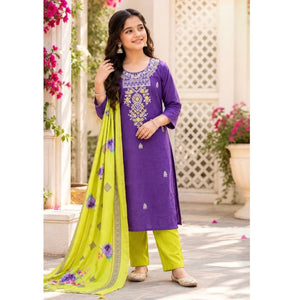 A woman models a purple salwar kameez suit with a bright lime green dupatta and matching lime green trousers, set against a traditional courtyard background.