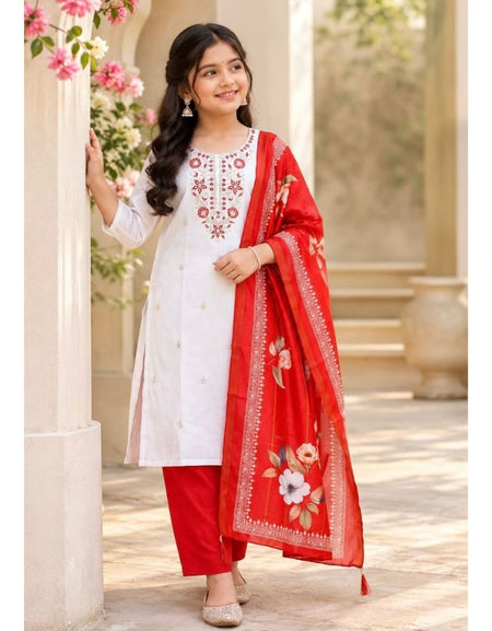A woman models a traditional Indian salwar kameez suit set. The outfit consists of a white long kurta with red floral embroidery on the chest, paired with solid red pants and a matching red dupatta featuring a floral border and embroidered details.
