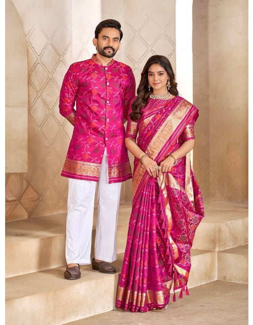 Load image into Gallery viewer, A man and a woman modeling traditional Indian formal wear. The man wears a bright pink embroidered kurta with white trousers, and the woman wears a matching pink and gold embroidered saree, standing on beige stone steps.
