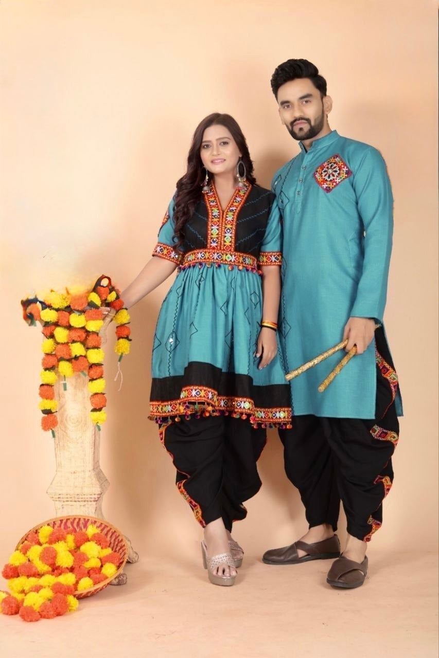 A man and a woman modeling matching ethnic wear against a solid beige studio background. The woman wears a turquoise and black kurta set with ornate embroidery, paired with black pants, while the man wears a matching turquoise kurta with a red embroidered chest motif and black pants.