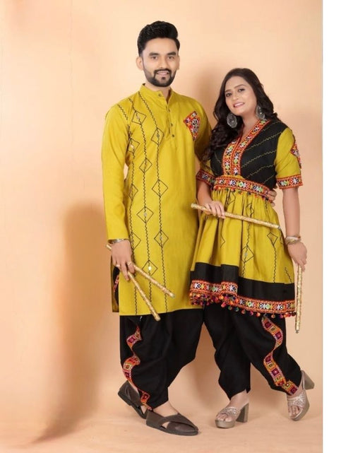 Load image into Gallery viewer, A couple modeling traditional Indian Navratri couple ethnic wear against a solid peach studio backdrop. The man wears a yellow kurta with black pants, and the woman wears a matching yellow and black kurta with red and gold border details.
