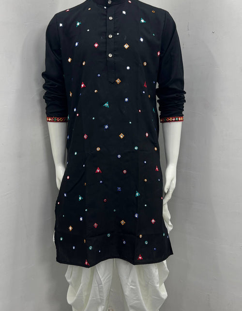 Load image into Gallery viewer, A black long-sleeve kurta with colorful embroidered geometric patterns, displayed on a white mannequin with white dhoti pants against a plain gray wall.
