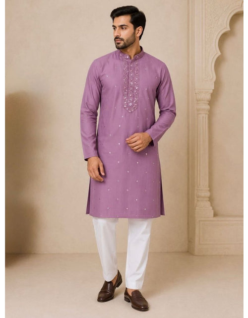 Load image into Gallery viewer, A man wearing a lavender purple kurta with silver embroidery on the chest and white trousers, standing in front of a beige architectural background.
