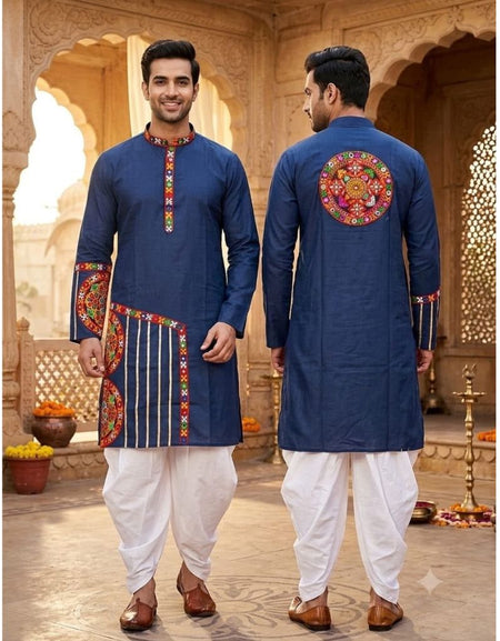 A man modeling a navy blue kurta with colorful embroidered details, shown from both the front and back views, paired with white dhoti pants and brown shoes in an ornate courtyard setting.