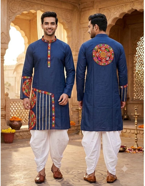 Load image into Gallery viewer, A man modeling a navy blue kurta with colorful embroidered details, shown from both the front and back views, paired with white dhoti pants and brown shoes in an ornate courtyard setting.
