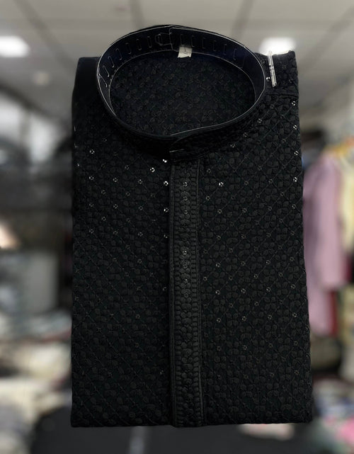 Load image into Gallery viewer, A folded black textured kurta with a stand collar and subtle silver embellishments, displayed against a blurred indoor background.
