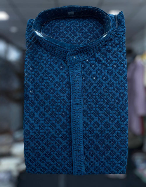 Load image into Gallery viewer, An ethnic blue patterned Kurta with a stand collar and decorative silver embellishments, shown against a blurred indoor background.
