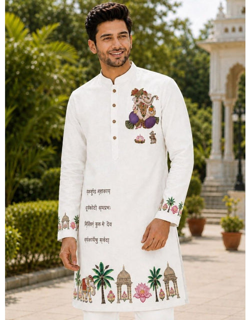 Load image into Gallery viewer, A man wearing a white long-sleeve kurta with colorful traditional Indian embroidery, standing outdoors in front of a garden and a white architectural structure.
