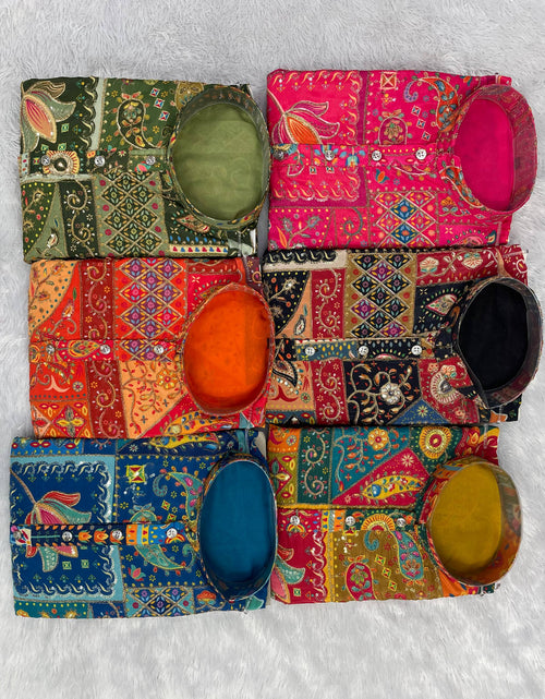 Load image into Gallery viewer, Six colorful embroidered fabric pouches or small bags arranged in a 2x3 grid on a white textured background, each with a matching oval fabric pouch placed on top. The fabrics feature intricate patchwork patterns in green, pink, orange, red, blue, black, and yellow.
