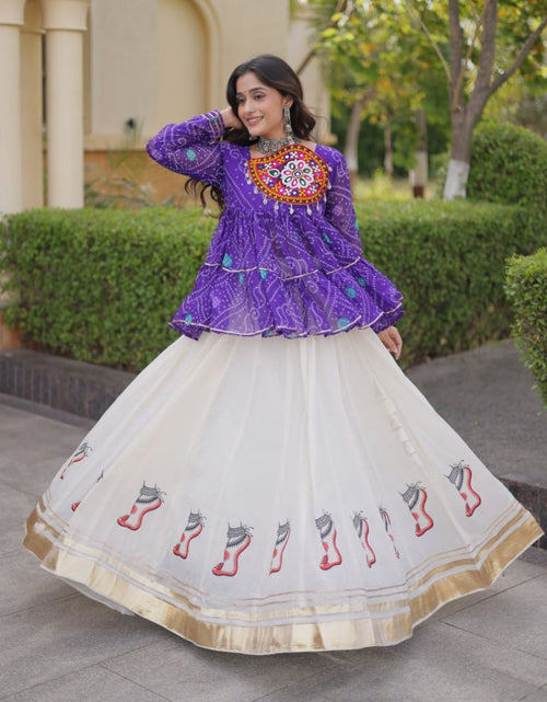 Load image into Gallery viewer, A woman modeling a traditional Indian outfit featuring a purple embroidered kurta paired with a voluminous white nette skirt decorated with red and gray motifs and a gold border, set against a garden background.
