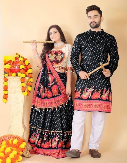 Load image into Gallery viewer, A couple modeling traditional Indian festive clothing. The woman wears a black and red lehenga choli with a white embroidered bodice, while the man wears a matching black kurta with red and gold motifs and white pants.
