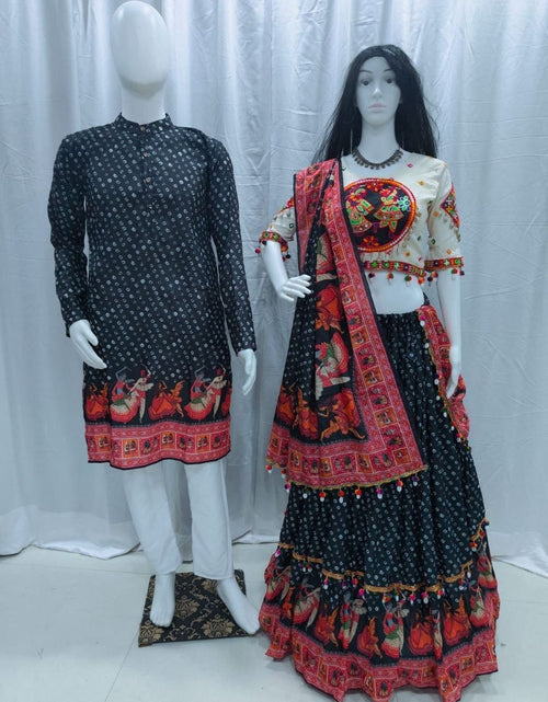 Load image into Gallery viewer, A traditional Indian ethnic Navratri Couple Wear Matching Outfit Set wear displayed on mannequins, featuring a black kurta with white prints and red border on the left, and a matching lehenga choli set on the right with a cream blouse, black skirt, and red patterned dupatta.
