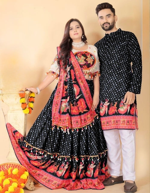 Load image into Gallery viewer, A couple posing in traditional Indian Navratri attire. The woman wears a black and red printed lehenga choli with a white blouse, and the man wears a matching black kurta with white pants.
