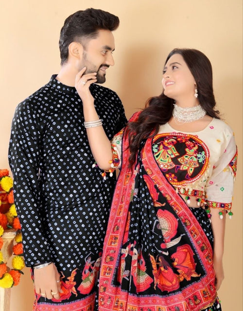 Load image into Gallery viewer, A couple wearing traditional South Asian clothing, featuring a black kurta with white polka dots and a matching black salwar with a vibrant red and multicolor embroidered dupatta, set against a plain beige background.
