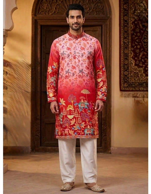 Load image into Gallery viewer, A man wearing a red and pink printed kurta with white trousers, standing in front of a traditional wooden door and wall panel.
