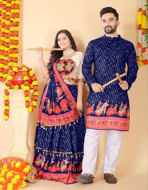 Load image into Gallery viewer, A man and a woman posing in traditional Indian attire. The woman wears a navy blue and red lehenga choli with intricate embroidery, and the man wears a matching navy blue kurta with red borders and white pants.
