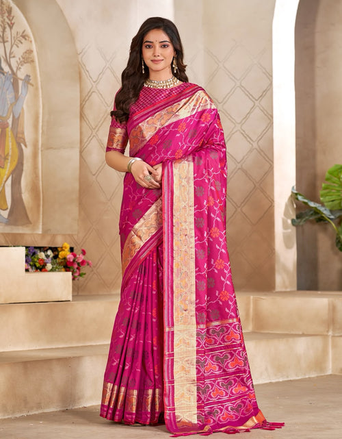 Load image into Gallery viewer, A woman modeling a bright pink and magenta silk saree with intricate gold and beige zari patterns, standing in a classical Indian architectural setting with beige arches.
