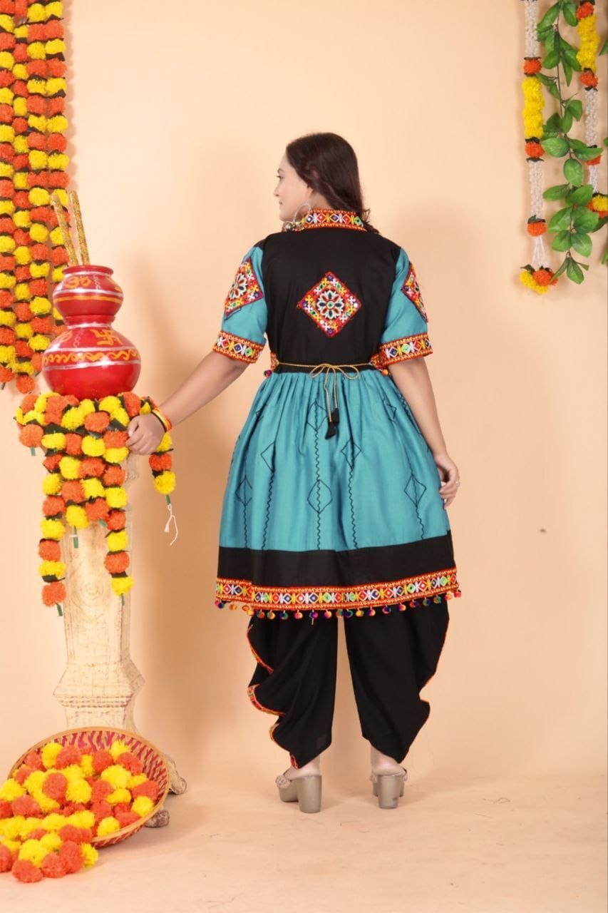 A woman wearing a traditional Indian Navratri kurta and dhoti pants set, shown from the back. The kurta is turquoise blue with a black yoke and colorful embroidered borders, paired with black dhoti pants.