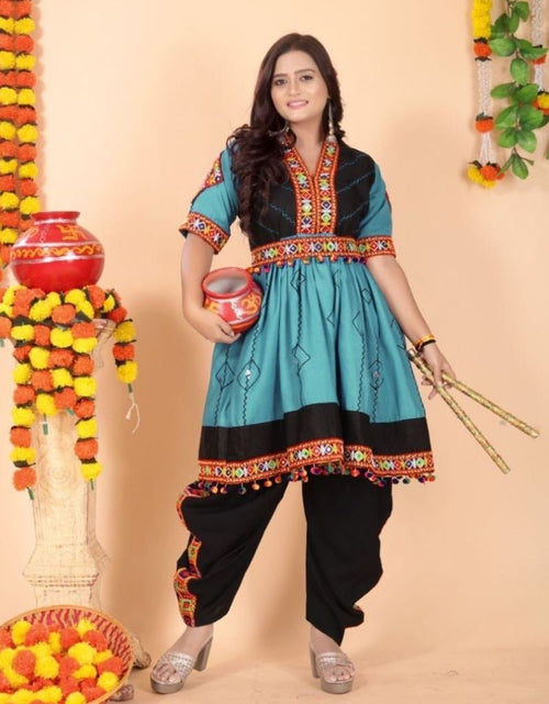 Load image into Gallery viewer, A woman modeling a traditional Indian salwar kameez suit. The outfit features a turquoise blue and black tunic with colorful embroidered borders, paired with black pants.

