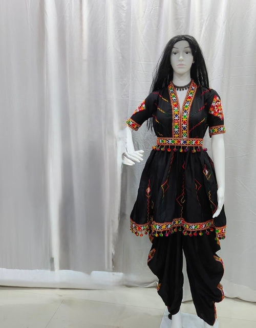 Load image into Gallery viewer, A black traditional outfit displayed on a mannequin against a white curtain backdrop. The outfit includes a short-sleeve top with colorful embroidered details around the neckline and sleeves, a matching embroidered waist tie, and black pants with decorative trim.
